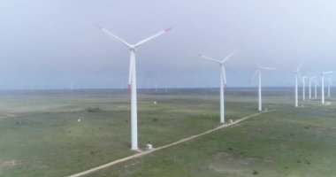 Yel değirmeni çiftliğinin 4K hava görüntüsü. Modern rüzgar türbinleri. Rüzgar en temiz, yenilenebilir enerji kaynağıdır.. 