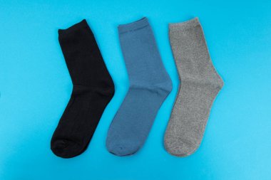 Mavi arka planda bir çift çorap. Uzun çoraplar Gri, mavi ve siyah,