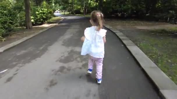 小女孩在外面的公园里跑 和他父亲一起玩追逐游戏抓住我 如果你可以 父亲和女儿在公园里互相追逐 — 图库视频影像