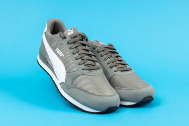 Varna, Bulgaristan - 18 Ağustos 2021. PUMA spor ayakkabısı mavi arka planda. Puma, büyük bir Alman çokuluslu şirketi. Ürün çekimi