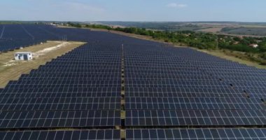 Fotovoltaik güneş çiftliğinin 4K hava görüntüsü. Güneş çiftliği elektrik santrali yukarıdan. Ekolojik yenilenebilir enerji.