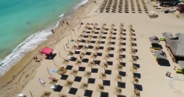 Plajda saman şemsiyeli 4K hava görüntüsü. Golden Sands, Zlatni Piasaci. Bulgaristan 'ın Varna kenti yakınlarındaki popüler tatil beldesi