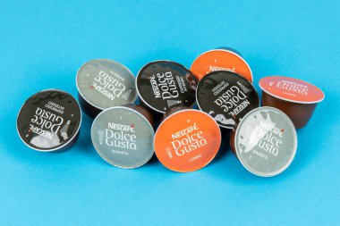VARNA, BULGARIA - 8 Eylül 2021: Mavi arka planda Nescafe Dolce Gusto kahve kapsülleri. 