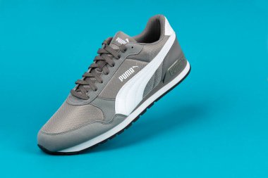 Varna, Bulgaristan - 18 Ağustos 2021. PUMA spor ayakkabısı mavi arka planda. Puma, büyük bir Alman çokuluslu şirketi. Ürün çekimi