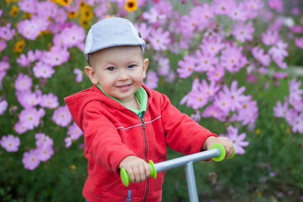 Rozkošný šťastný usměvavý chlapec hraje v zahradě — Stock fotografie