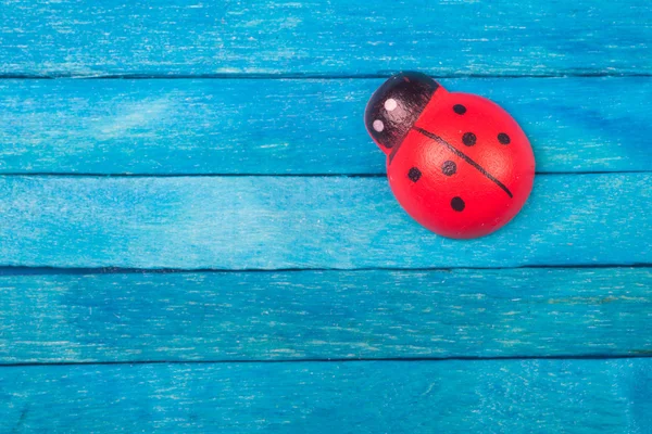 Ladybug on blue wooden background — Stock Photo, Image