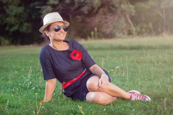 Portrait of a young smiling woman in the park — Stock Photo, Image