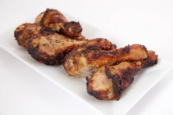 Grillowane nogi kurczaka (pałeczki perkusyjne) na białym talerzu — Zdjęcie stockowe