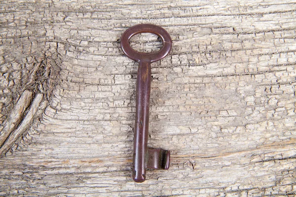 Gammal nyckel på trä bakgrund — Stockfoto