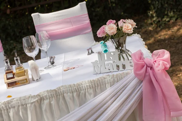 Sinal apenas casado com um monte de rosas e fita rosa na mesa de casamento — Fotografia de Stock