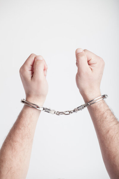 closeup of the hands of a man with handcuffs