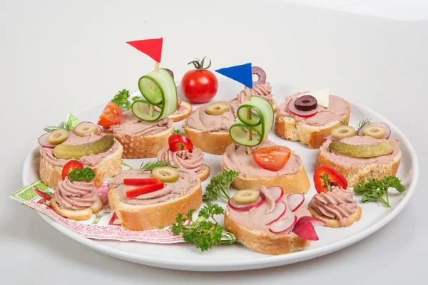 Piatto da festa con fette di pane con patè fatto in casa, decorato con verdure — Foto Stock
