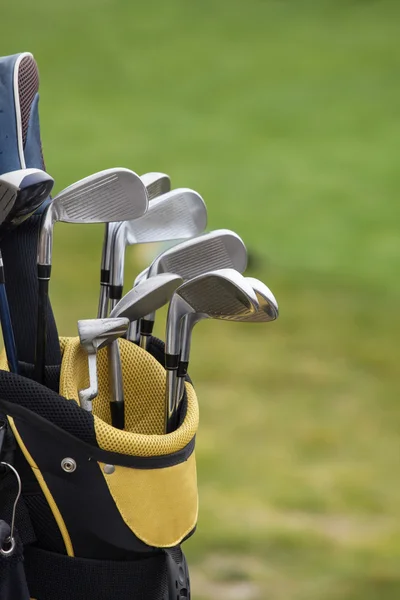 Conjunto de palos de golf sobre fondo de campo verde —  Fotos de Stock