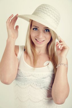 Genç sarışın kız wiyh beyaz şapka ve kıyafet gülümseyen