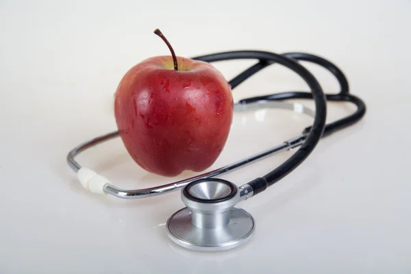 Medical stethoscope and red apple. Healty food — Stock Photo, Image