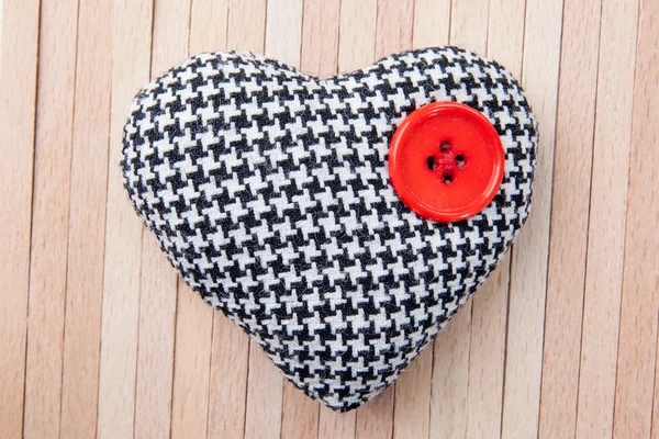 Heart with red button over a wooden background — Stock Photo, Image