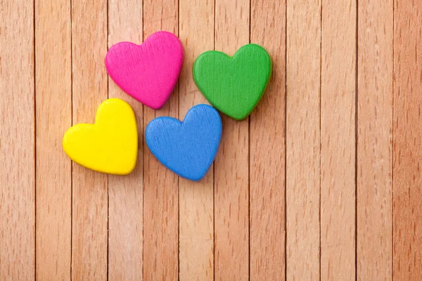 Colorful hearts over a wooden background — Stock Photo, Image