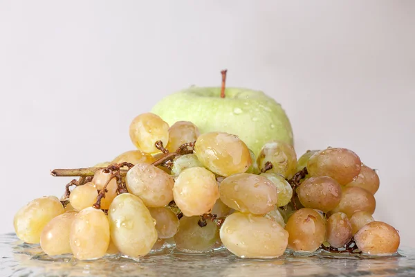 Fresh grapes and apple in water. Healthy food — Stock Photo, Image