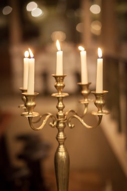 Vintage bronze candlestick with burning candles  clipart