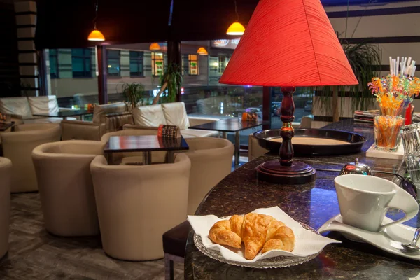 Croissant og kaffe kop på coffeeshop - Stock-foto