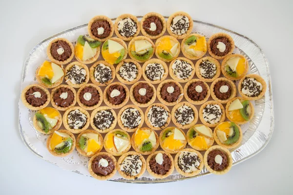 Bandeja de fiesta con cupcakes pequeños con diferentes rellenos, catering de alimentos — Foto de Stock