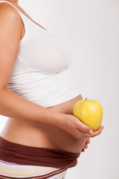 Schwangere hält einen Apfel in der Hand — Stockfoto