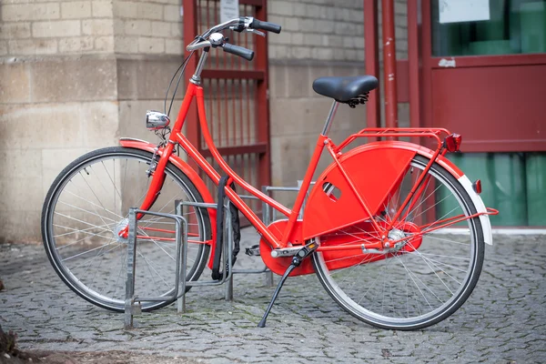 Ciclismo rojo estacionado en la ciudad — Foto de Stock