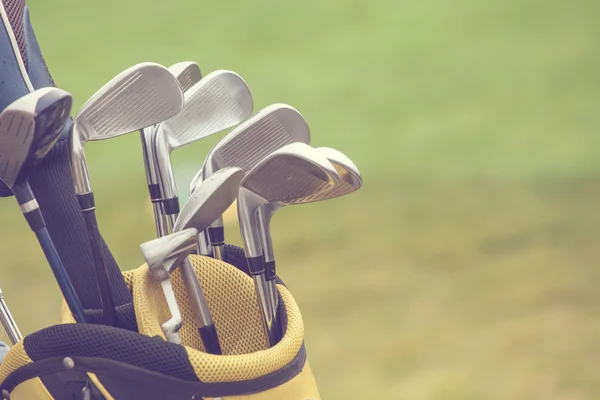 Conjunto de palos de golf sobre fondo de campo verde — Foto de Stock