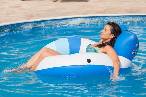 Jovem mulher desfrutando de uma piscina — Fotografia de Stock