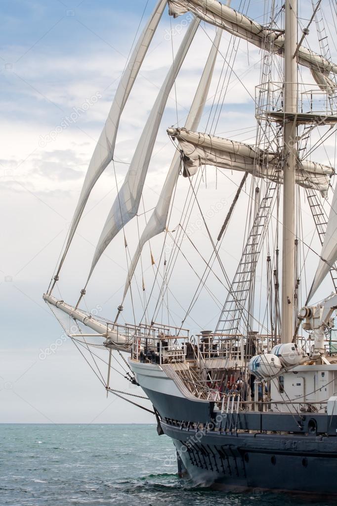 Old ship with white sales sailing in the sea