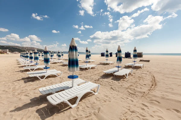 Sok strand székek és zárt napernyők, a gyönyörű strandoktól, felhős kék ég — Stock Fotó