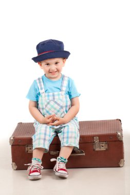 Bagaj üzerinde oturan çocuk. Çocuk tatil seyahat kavramı