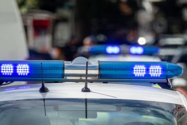 Mavi bir polis arabasının ışıklı barına ve devriye aracının sirenine yakın çekim. Kanun uygulama, acil durum hizmetleri, kamu güvenliği ve adalet kavramı.