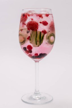 Pembe köpüklü, ahududu, salatalık dilimleri ve şarap kadehinde buz küpleriyle ferahlatıcı bir kokteyl. İçki, yaz ve partiler için mükemmel..