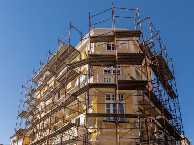 Geniş metal iskeleli tarihi bir binanın cephe restorasyonu. Kentsel yenileme, inşaat ve gayrimenkul geliştirme kavramı. 