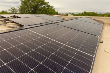 Modern çatı güneş panelleri güneşli bir günde temiz yenilenebilir enerji üretiyor. Çevre dostu evler, yeşil altyapı ve çevresel koruma için sürdürülebilir enerji teknolojisi
