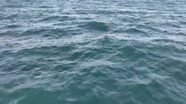 İnsansız hava aracı okyanus ve deniz üzerinde uçuyor. Suya yakın.