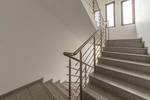 Katlar arasında modern merdiven. Modern binada metal parmaklıklı merdivenler. Çağdaş bir apartman ya da ofis binası. Mimarlık ve gayrimenkul geçmişi.