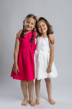 Stüdyoda sarılıp gülümseyen mutlu genç kızlar. Çocukluk arkadaşlığı, kardeşlik, masumiyet, neşeli çocuklar, aile sevgisi, bağlanma ve pozitif duygu.