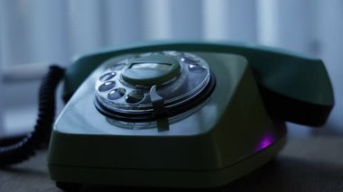 Telefon ahizesini kaldıran ve eski bir telefondan numara çeviren bir elin yakın görüntüsü. Retro plastik telefon.