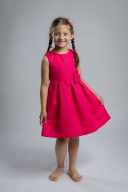 Stüdyoda Pembe Elbiseli Gülümseyen Genç Kız. Mutlu Çocukluk Moda Portresi, Çocuk Giysileri, Kutlama, Doğum Günü ve Aile Yaşam Tarzı Konsepti