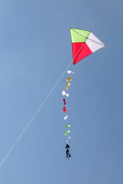 Cometa colorida volando en un hermoso cielo azul — Foto de Stock