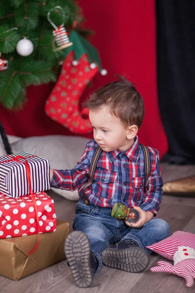 Kleiner Junge mit Weihnachtsgeschenken vor dem Weihnachtsbaum — Stockfoto