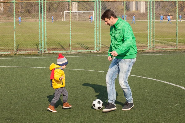 Padre joven con su pequeño hijo jugando fútbol, fútbol en el parque — Foto de Stock