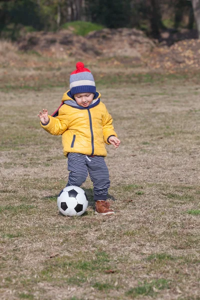 Mały chłopiec bawiący się piłką nożną lub piłką. sport do ćwiczeń i aktywności. — Zdjęcie stockowe