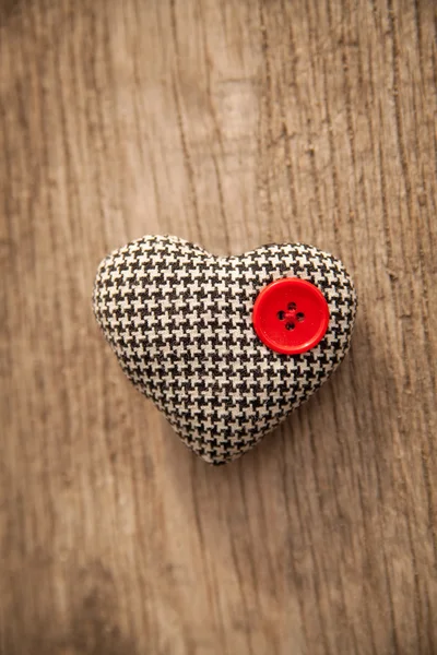 Heart with red button over a wooden background — Stock Photo, Image