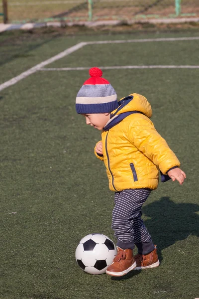 Маленький мальчик играет в футбол или футбольный мяч. спорт для занятий спортом. — стоковое фото