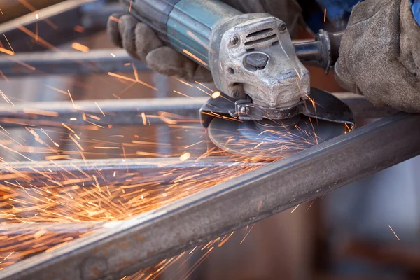 Trabalhador da fábrica usando moedor elétrico máquina de corte de metal. Espumantes — Fotografia de Stock