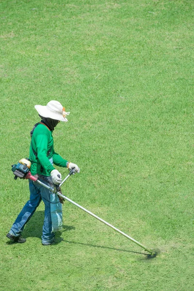 Homme tondre l'herbe — Photo