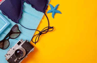 Top view Yatağı, Seyahat ve tatil konsepti öğeleri sarı masada. Fotokopi alanı, kamera ve plaj aksesuarlarıyla yaz manzarası